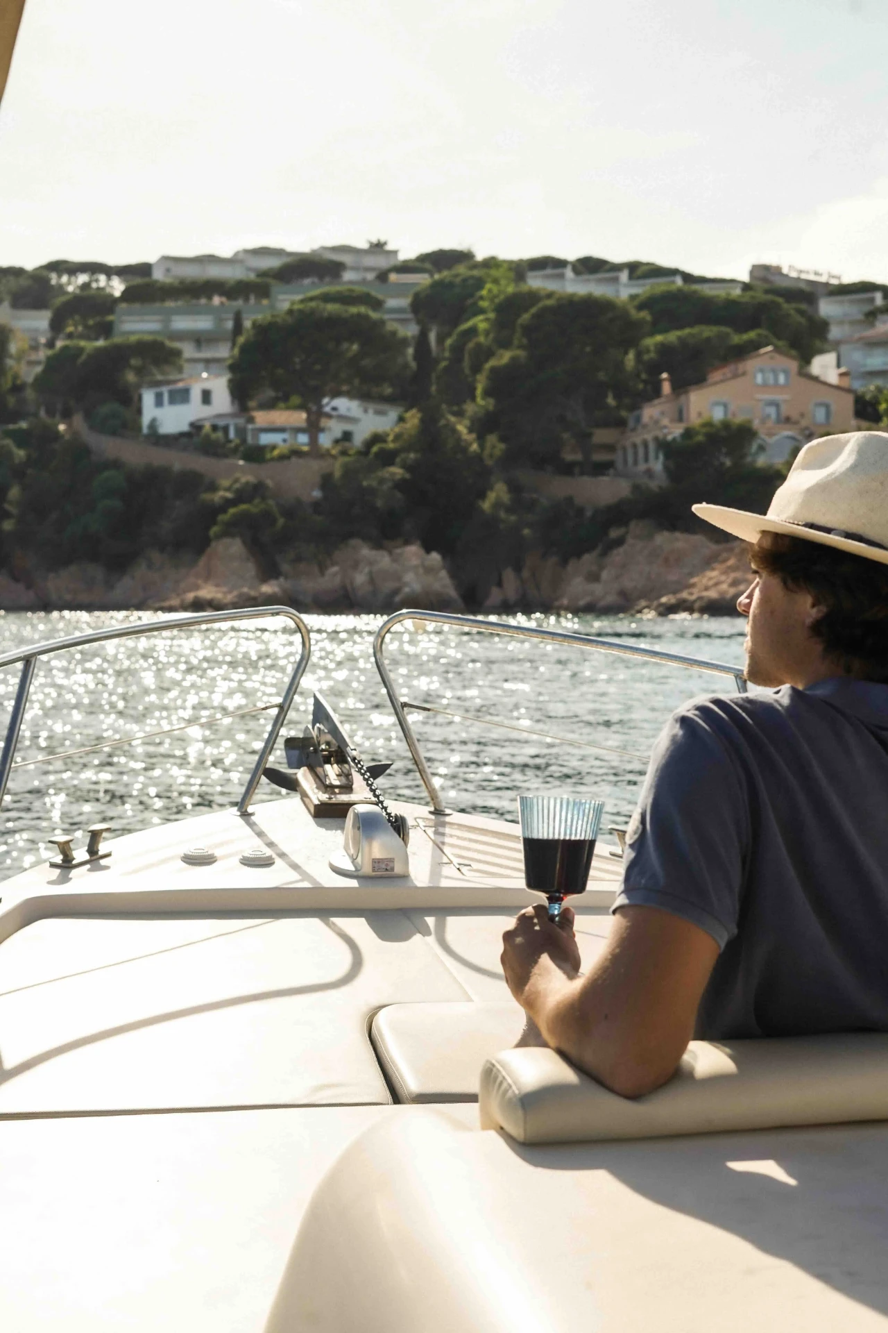 Guest enjoying a glass of wine on deck during a private Costa Brava boat tour from Barcelona