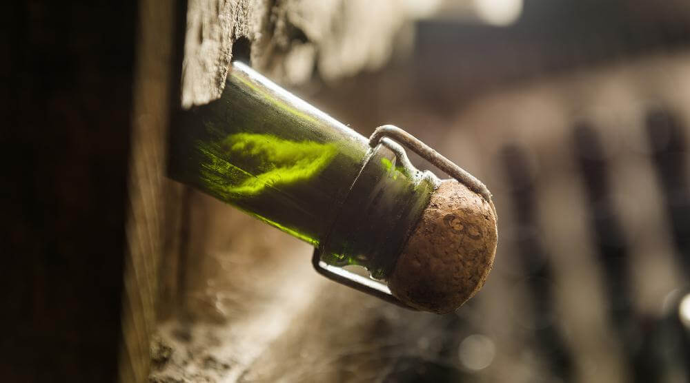 Close-up of a cava bottle during dégorgement with a frozen plug of sediment in the neck