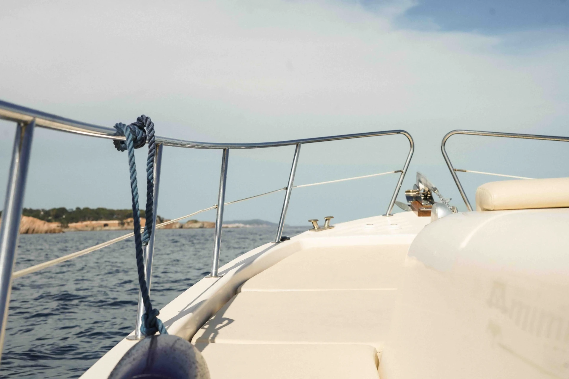 Bow railing of a private motor boat overlooking the Costa Brava coastline
